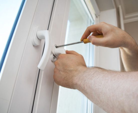 Professional handyman fixing window handle at home.